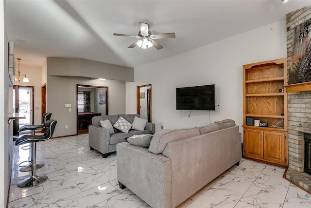 living room with ceiling fan and a fireplace