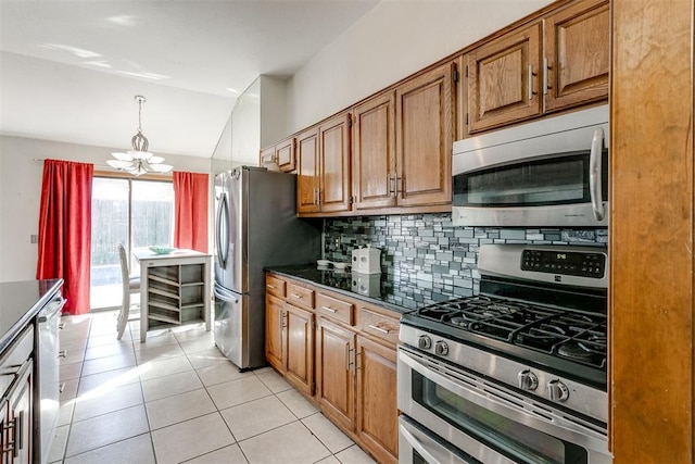 kitchen with light tile patterned floors, stainless steel appliances, an inviting chandelier, and lofted ceiling