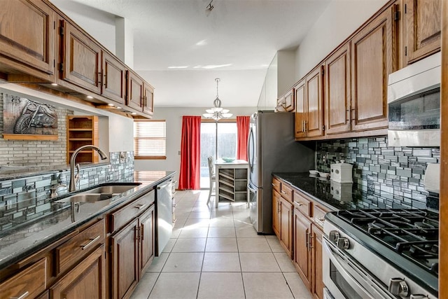 kitchen with appliances with stainless steel finishes, sink, tasteful backsplash, and light tile patterned flooring