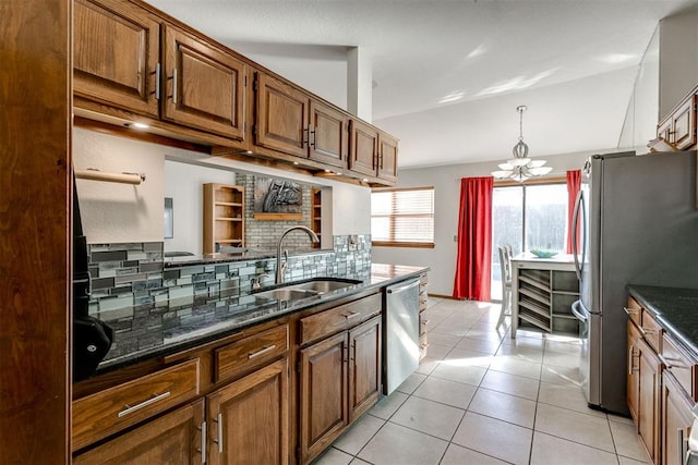 kitchen with sink, decorative backsplash, appliances with stainless steel finishes, a notable chandelier, and light tile patterned flooring