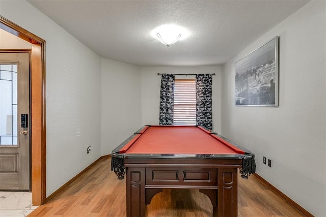 game room with light hardwood / wood-style floors, a textured ceiling, and billiards