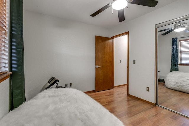 bedroom with ceiling fan, light wood-type flooring, and a closet