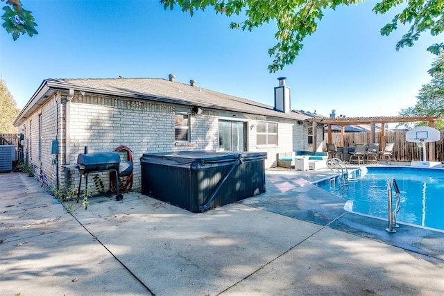 exterior space featuring a patio, a hot tub, and grilling area