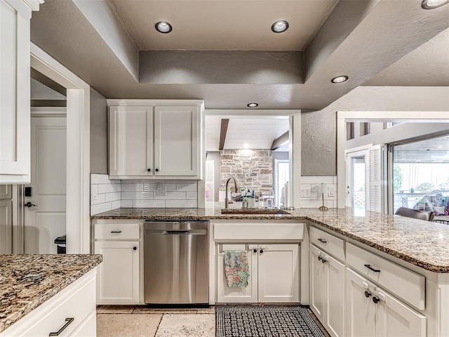 kitchen featuring decorative backsplash, light stone counters, sink, and white cabinets