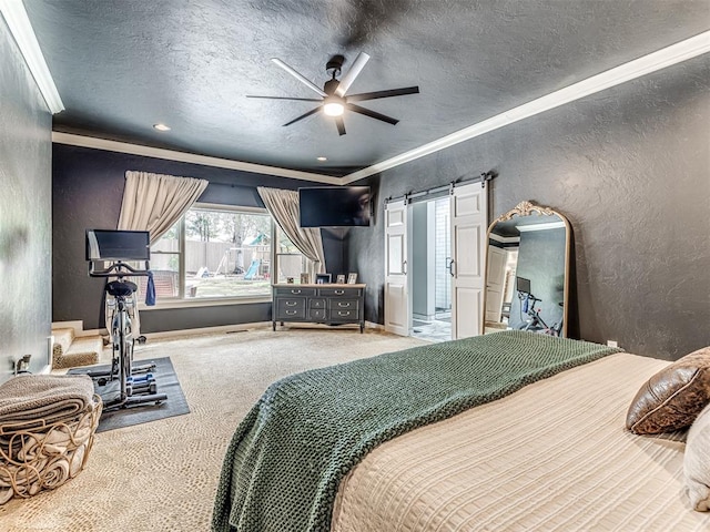 bedroom featuring ceiling fan, a barn door, crown molding, a textured ceiling, and carpet