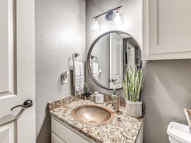 bathroom featuring vanity and toilet