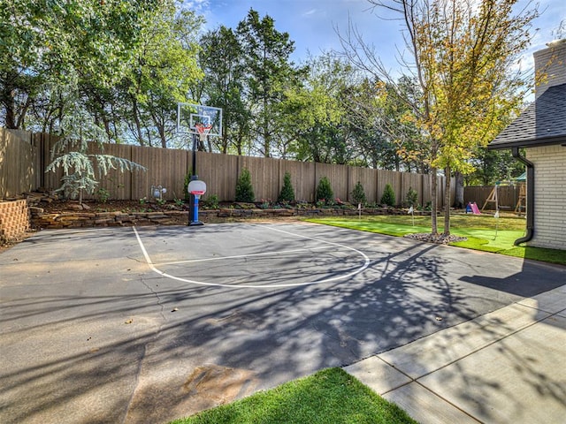 view of basketball court with a playground and a yard