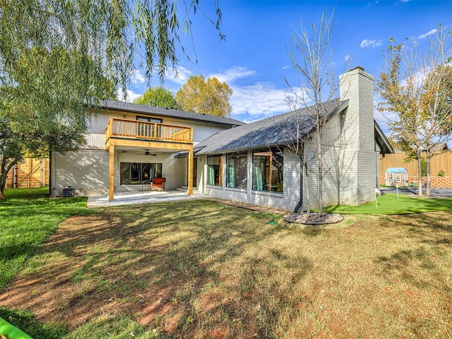 back of property with a lawn, a patio area, ceiling fan, and a balcony