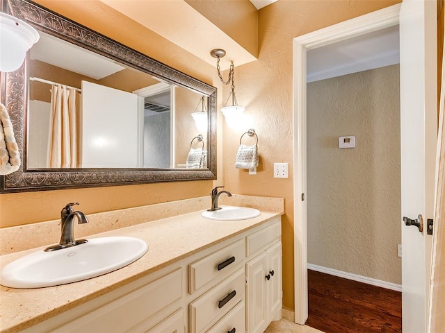 bathroom with curtained shower, vanity, and hardwood / wood-style flooring