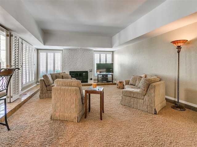 carpeted living room featuring a wealth of natural light and a brick fireplace