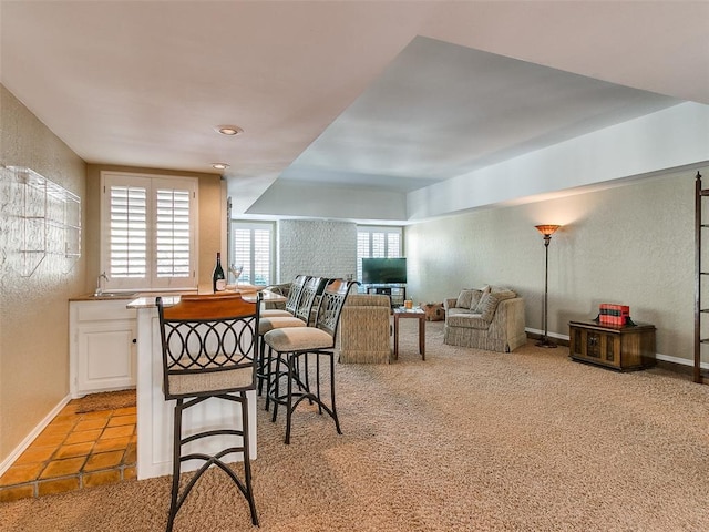 dining space featuring sink and light colored carpet