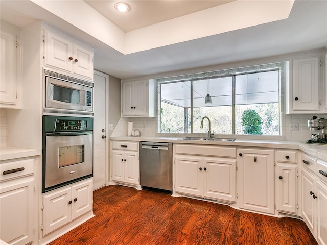 kitchen with tasteful backsplash, white cabinets, and stainless steel appliances