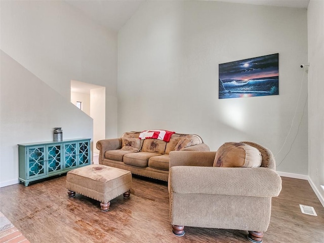 living room featuring high vaulted ceiling and hardwood / wood-style flooring