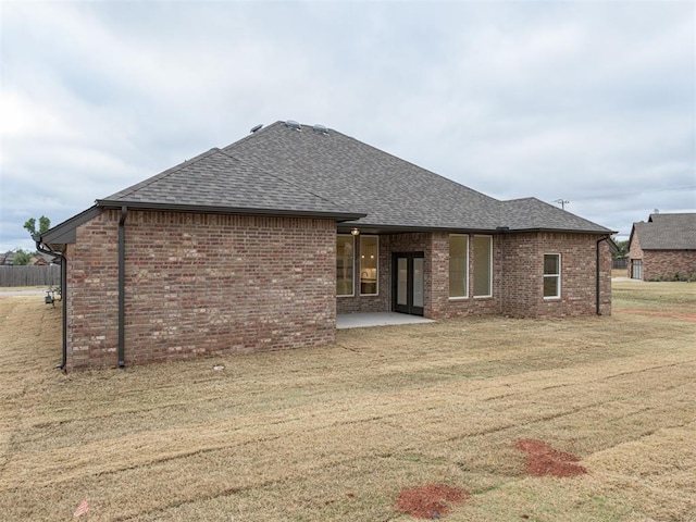 back of property with a yard and a patio