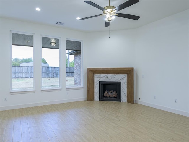 12129 SW 45th Ter, Mustang, OK 73064 - unfurnished living room with wood finished floors, a ceiling fan, baseboards, recessed lighting, and a high end fireplace