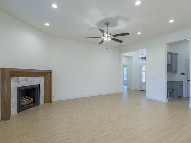 12129 SW 45th Ter, Mustang, OK 73064 - unfurnished living room featuring ceiling fan, light wood-style flooring, recessed lighting, baseboards, and a high end fireplace