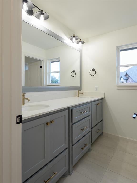 12129 SW 45th Ter, Mustang, OK 73064 - full bathroom with double vanity, tile patterned floors, and baseboards