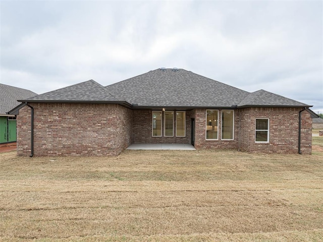 12129 SW 45th Ter, Mustang, OK 73064 - back of house with a shingled roof, a patio, a yard, and brick siding