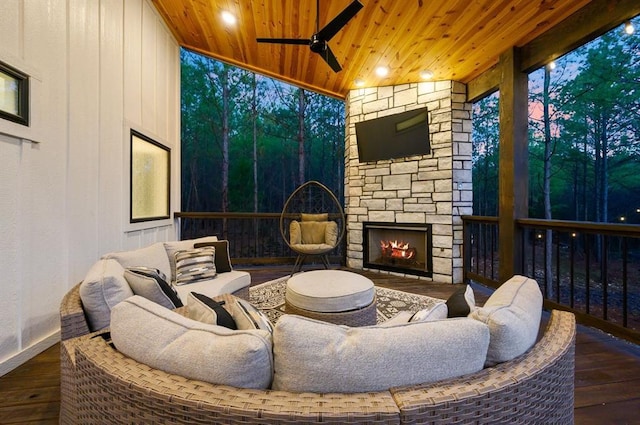 sitting room with hardwood / wood-style flooring, ceiling fan, wooden ceiling, and an outdoor stone fireplace