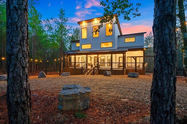 back house at dusk featuring a porch