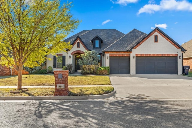 view of front of home with a garage and a front lawn