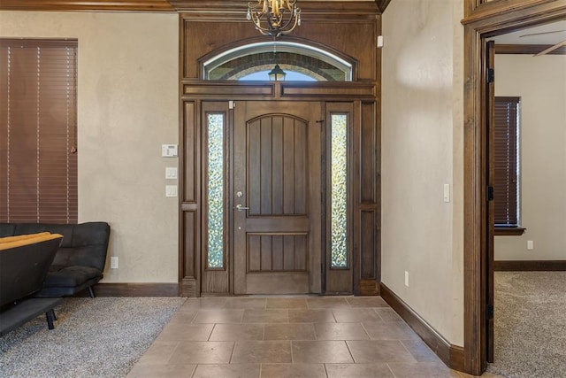 entrance foyer with ornamental molding and a notable chandelier