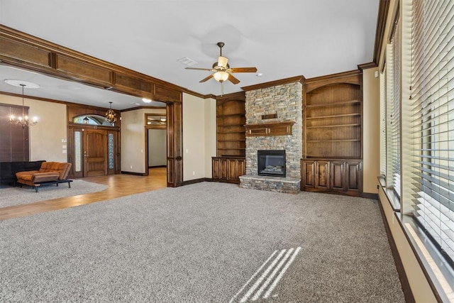 unfurnished living room featuring a fireplace, built in features, crown molding, and light carpet