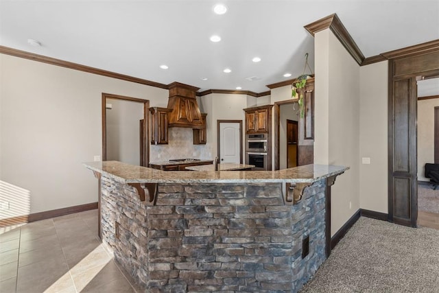 kitchen featuring kitchen peninsula, appliances with stainless steel finishes, a breakfast bar area, light tile patterned floors, and custom exhaust hood