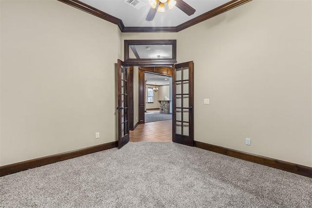 carpeted empty room featuring ceiling fan, french doors, and crown molding