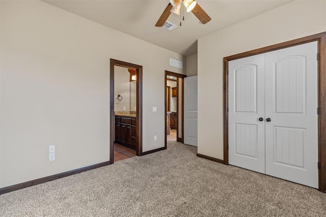 unfurnished bedroom with connected bathroom, carpet floors, a closet, and ceiling fan