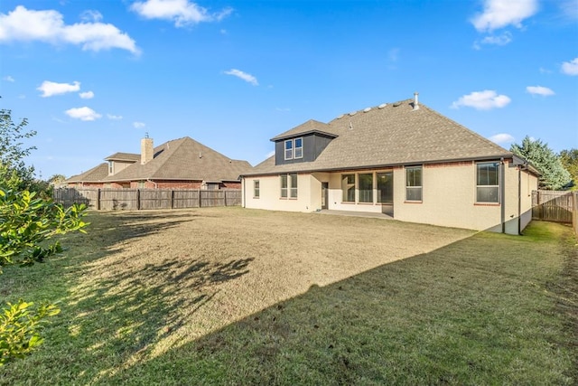 rear view of house featuring a lawn