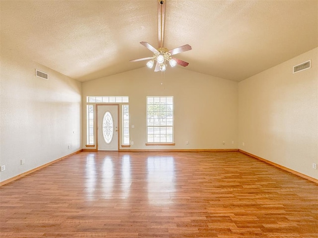 interior space featuring a textured ceiling, light hardwood / wood-style floors, ceiling fan, and lofted ceiling