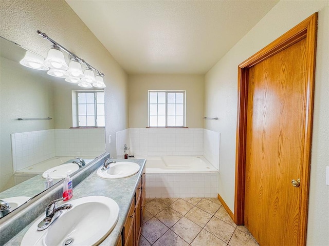 bathroom with tile patterned floors, vanity, and tiled bath