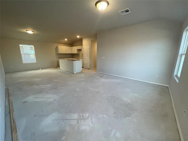 unfurnished living room featuring vaulted ceiling