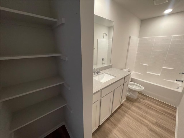 full bathroom with wood-type flooring,  shower combination, vanity, and toilet