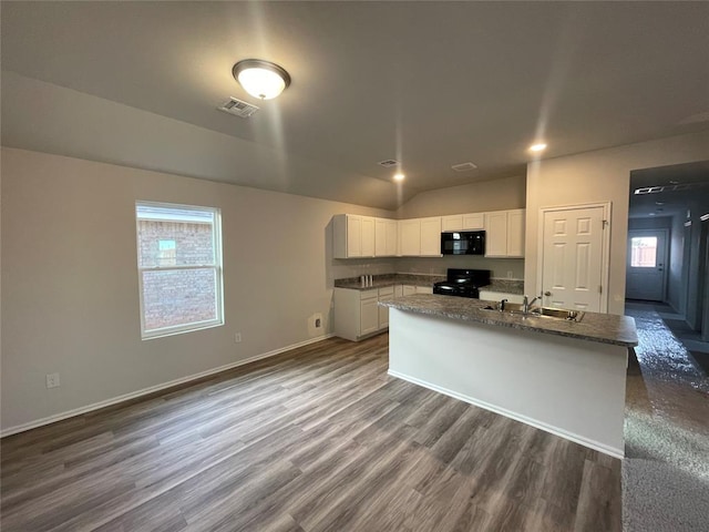 kitchen featuring sink, white cabinetry, hardwood / wood-style flooring, dark stone counters, and black appliances