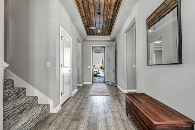 entrance foyer featuring hardwood / wood-style flooring, a tray ceiling, and wood ceiling