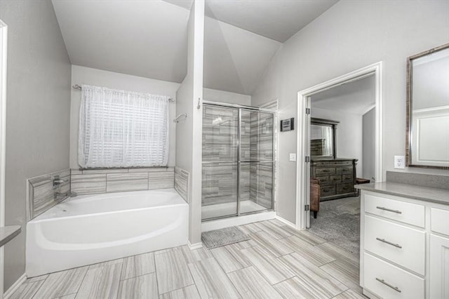 bathroom featuring vanity, independent shower and bath, and lofted ceiling