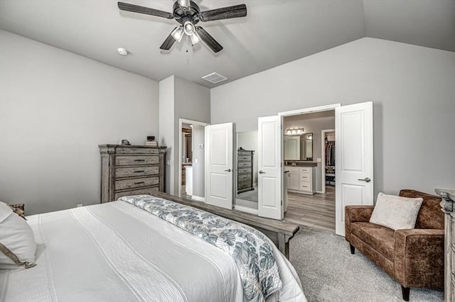 bedroom featuring connected bathroom, light hardwood / wood-style flooring, ceiling fan, and lofted ceiling