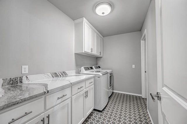 clothes washing area with cabinets and washing machine and dryer