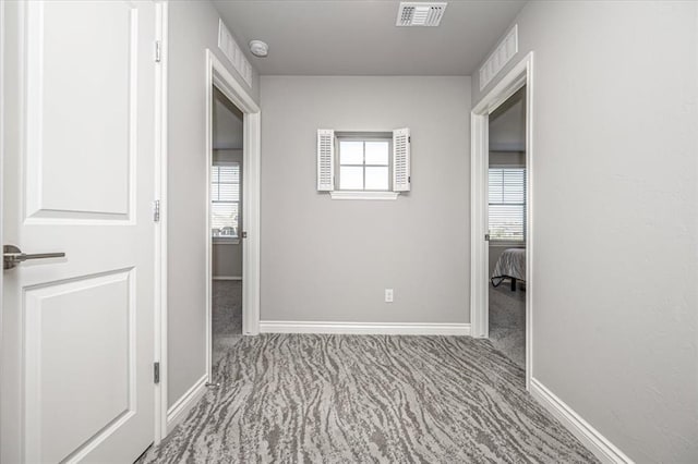 hallway featuring light colored carpet