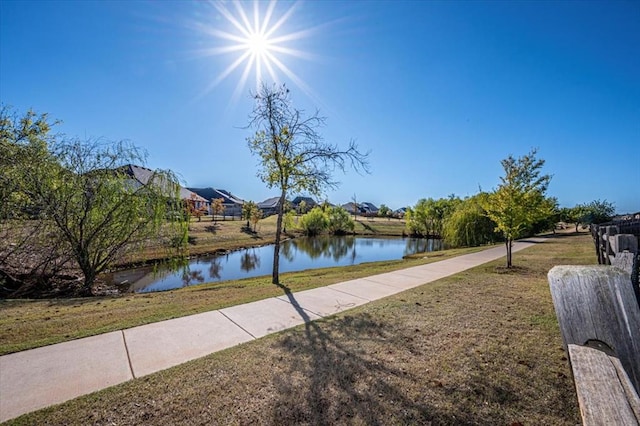 surrounding community featuring a water view and a yard