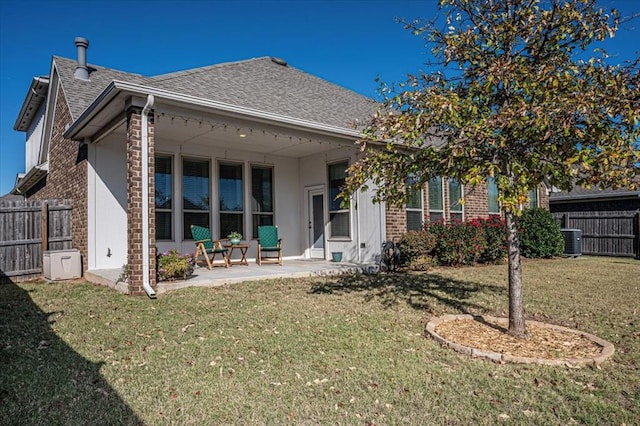 back of house with a lawn, central AC, and a patio