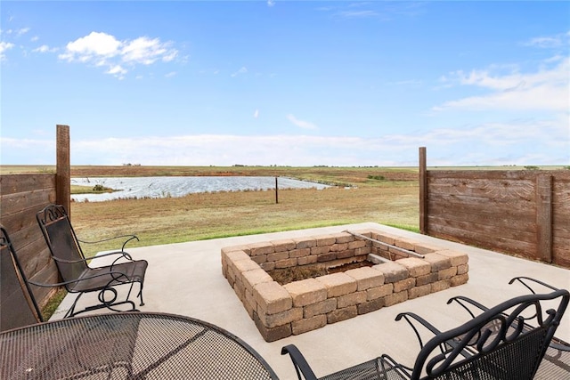 view of patio featuring a water view and an outdoor fire pit