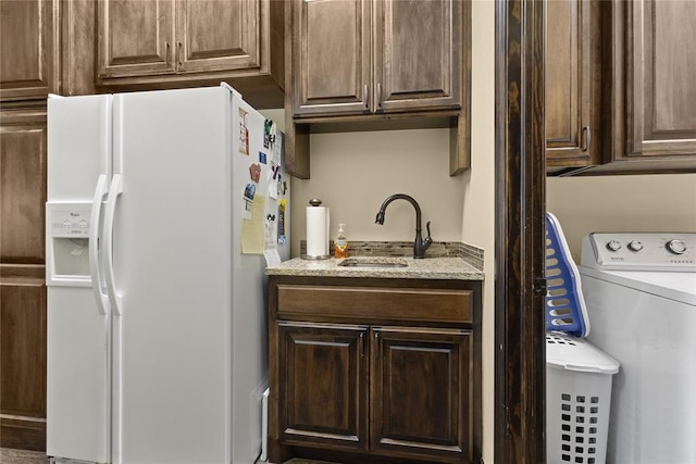 interior space with washer / clothes dryer, sink, and white fridge with ice dispenser