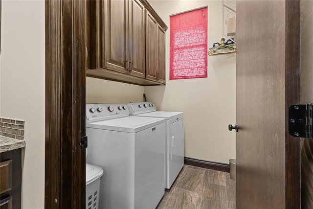 clothes washing area with cabinets and independent washer and dryer