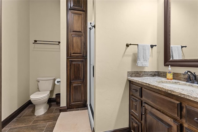 bathroom featuring vanity, tasteful backsplash, and toilet