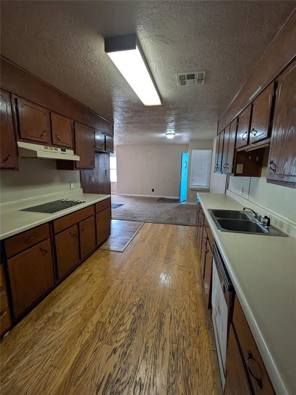 kitchen with black electric stovetop, a textured ceiling, sink, light hardwood / wood-style flooring, and dishwasher