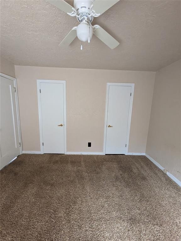 spare room with carpet flooring, ceiling fan, and a textured ceiling