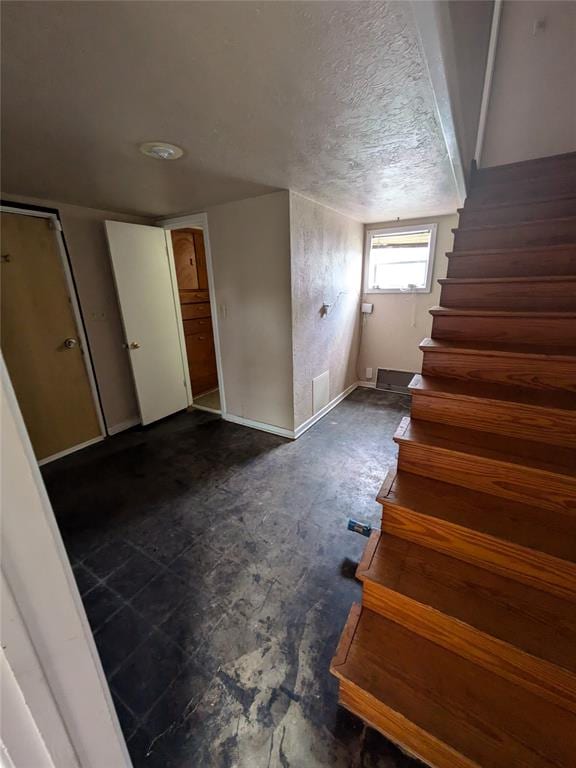 stairs with a textured ceiling